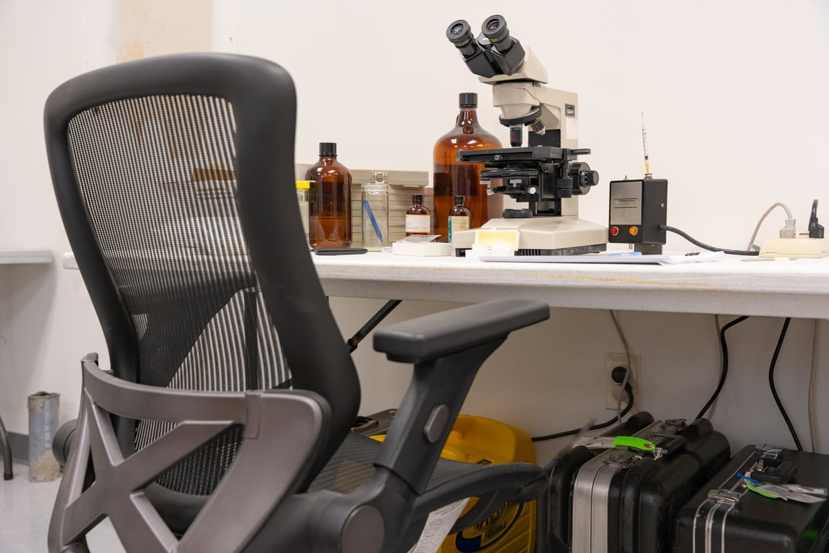 Photography of a asbestos analysis area with various equipment on table.